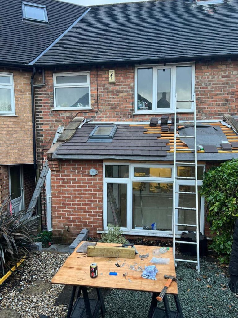 This is a photo of a roof extension that is having new roof tiles installed. This is a photo taken from the roof ridge looking down a tiled pitched roof on to a flat roof. Works carried out by Erith Roofing Repairs