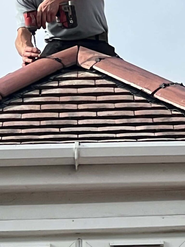 This is a photo of one of the operatives of Erith Roofing Repairs installing new ridge tiles